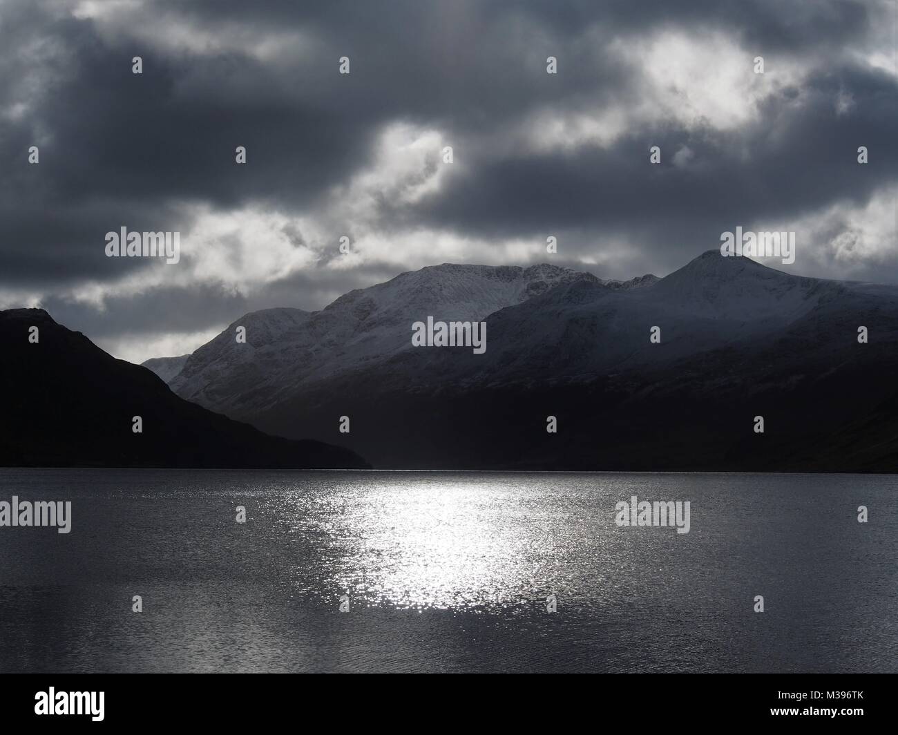 Il sole invernale sul Crummock acqua con Buttermere Fells oltre, Parco Nazionale del Distretto dei Laghi, Cumbria, Regno Unito Foto Stock