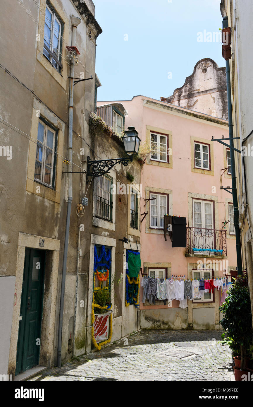 Un tipico acciottolato stretto Street nel quartiere di Alfama, Lisbona, Portogallo Foto Stock