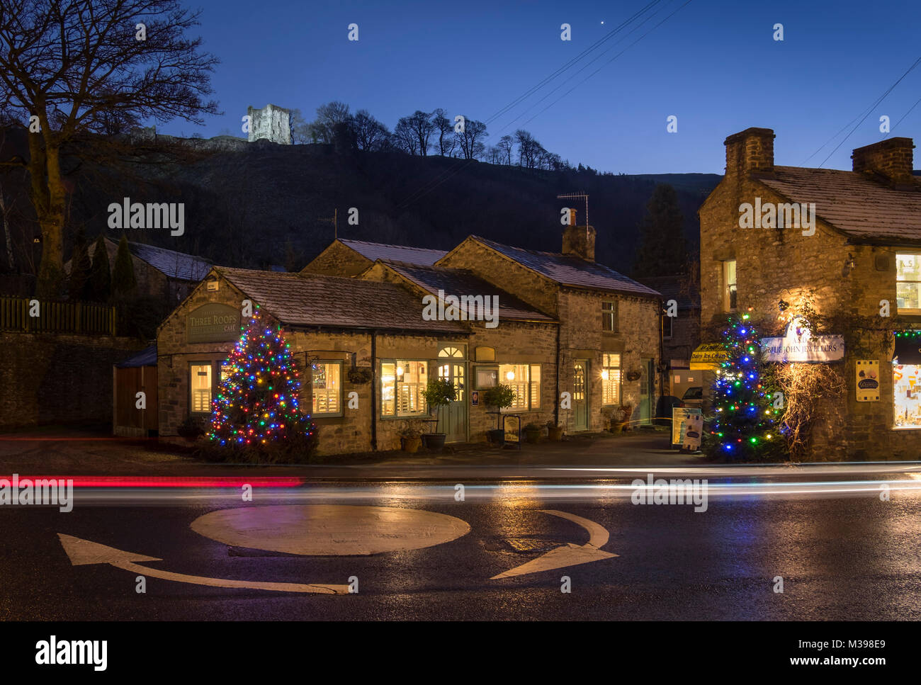 Negozi in Castleton a Natale sostenuta da: Peveril Castle di notte, il Parco Nazionale di Peak District, Derbyshire, England, Regno Unito Foto Stock