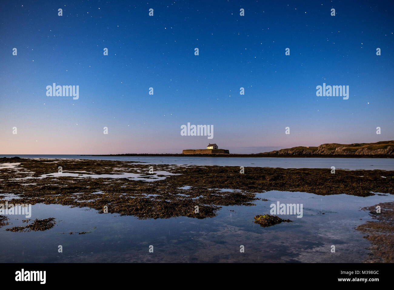 Il cielo di notte su St Cwyfan la Chiesa, Aberffraw, Anglesey, Galles del Nord, Regno Unito Foto Stock