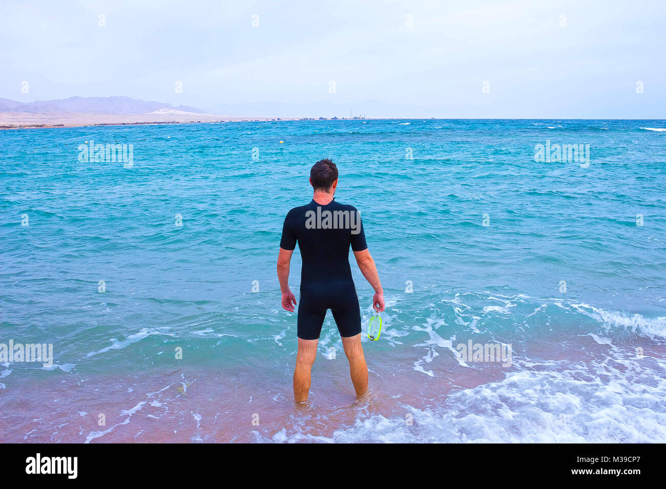 Giovane uomo nella muta va al mare in estate all'aperto Foto stock - Alamy