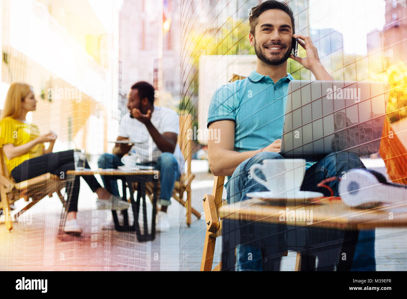 Dipendente di successo cercando felice pur avendo una piacevole conversazione telefonica Foto Stock