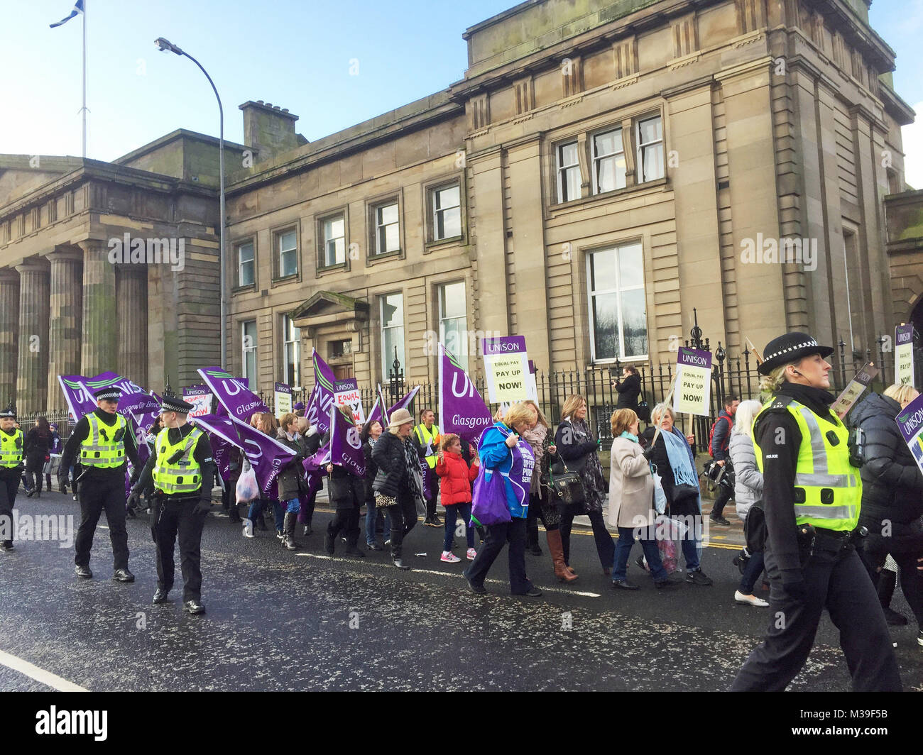 Centinaia di donne, alcuni vestiti come suffragettes, marzo attraverso chiamate di Glasgow per la parità di retribuzione dal consiglio della città. Foto Stock