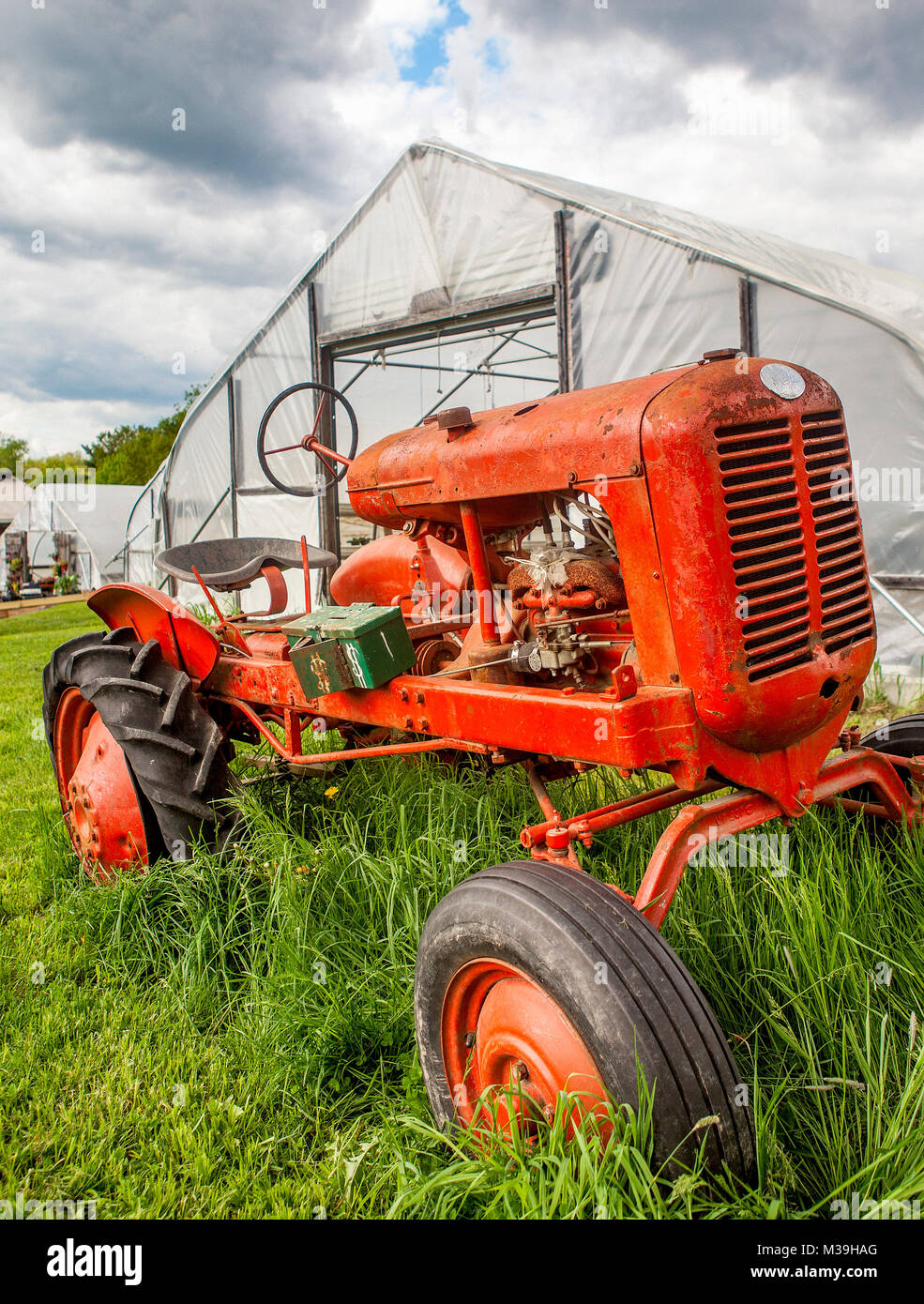 Un vecchio, rosso, vintage che il trattore è stato ridefinito come un "paghi' cassa in una fattoria di stand in New Hampshire, Stati Uniti d'America. Foto Stock