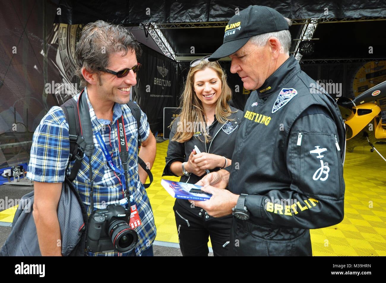 Autore Paul Fiddian presentando il suo libro per il pilota di Nigel Agnello con Breitling team PR Victoria Griffiths.La storia di Biggin Hill International Air Foto Stock