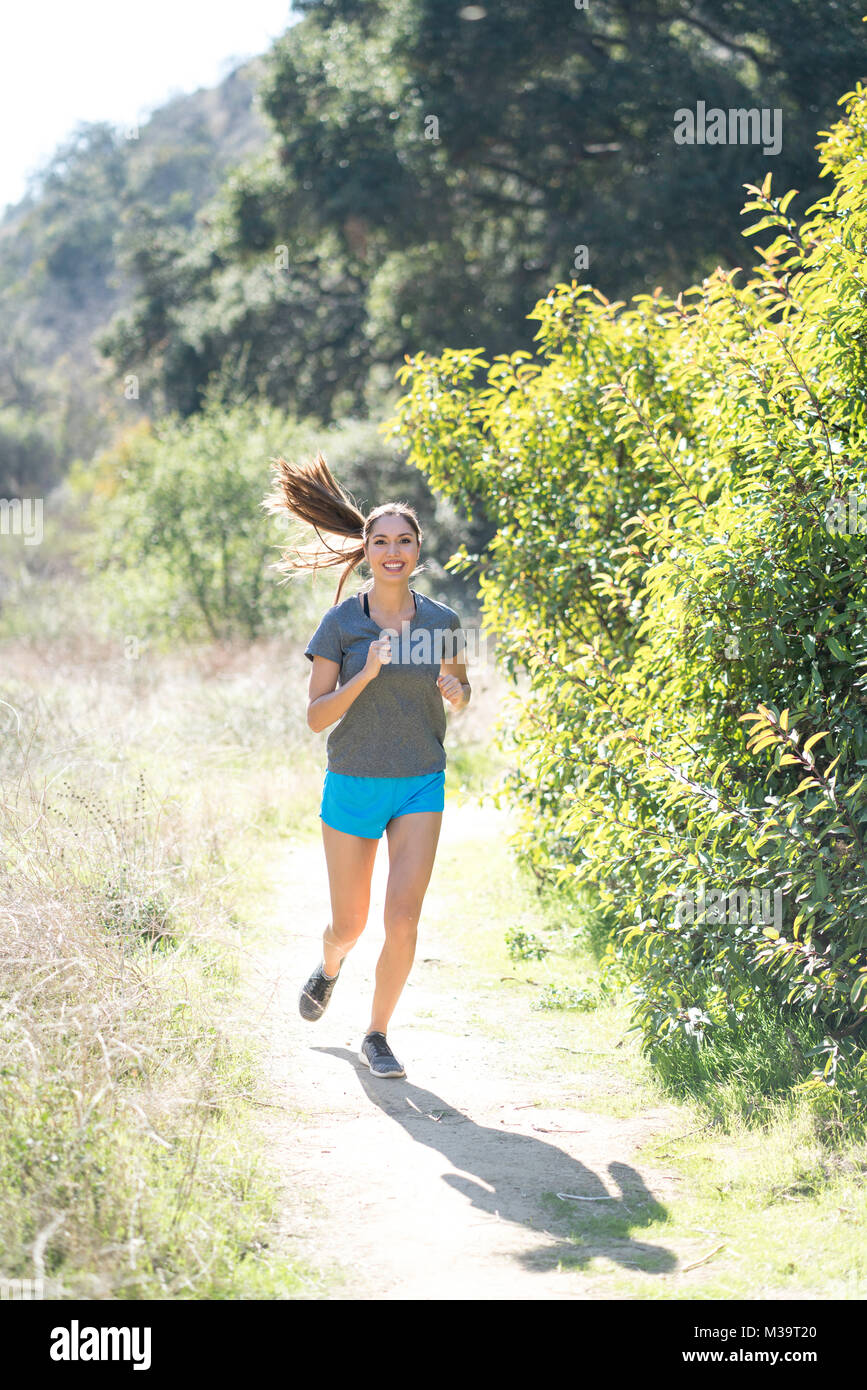 Femmina jogging all'aperto sul sentiero di idoneità Foto Stock