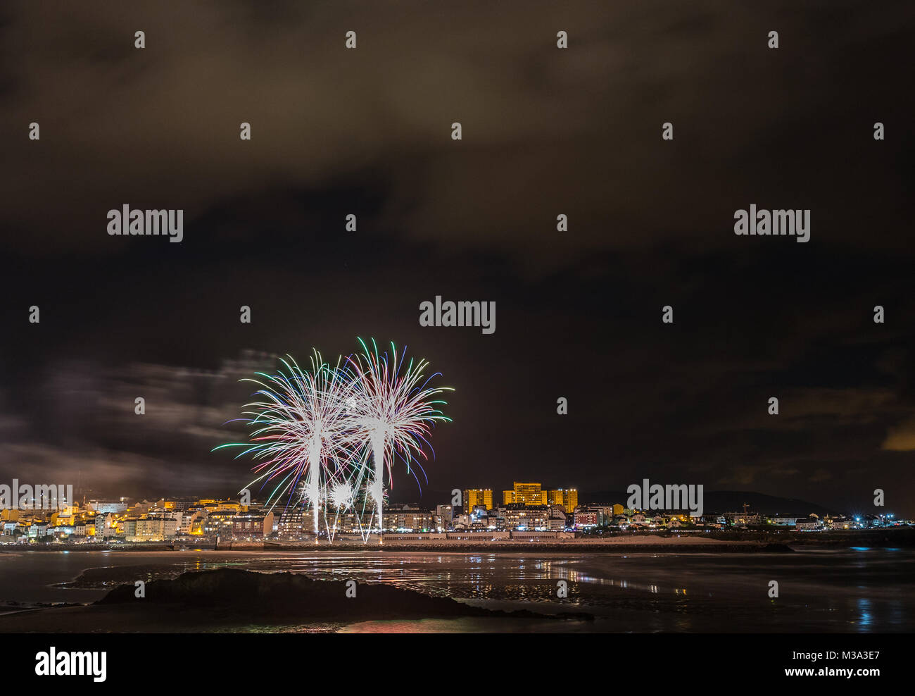 Vacanze in costa della Galizia, dove di notte per celebrare i festeggiamenti nella città di Foz, Spagna, contempliamo i fuochi d'artificio degno di ammirazione Foto Stock