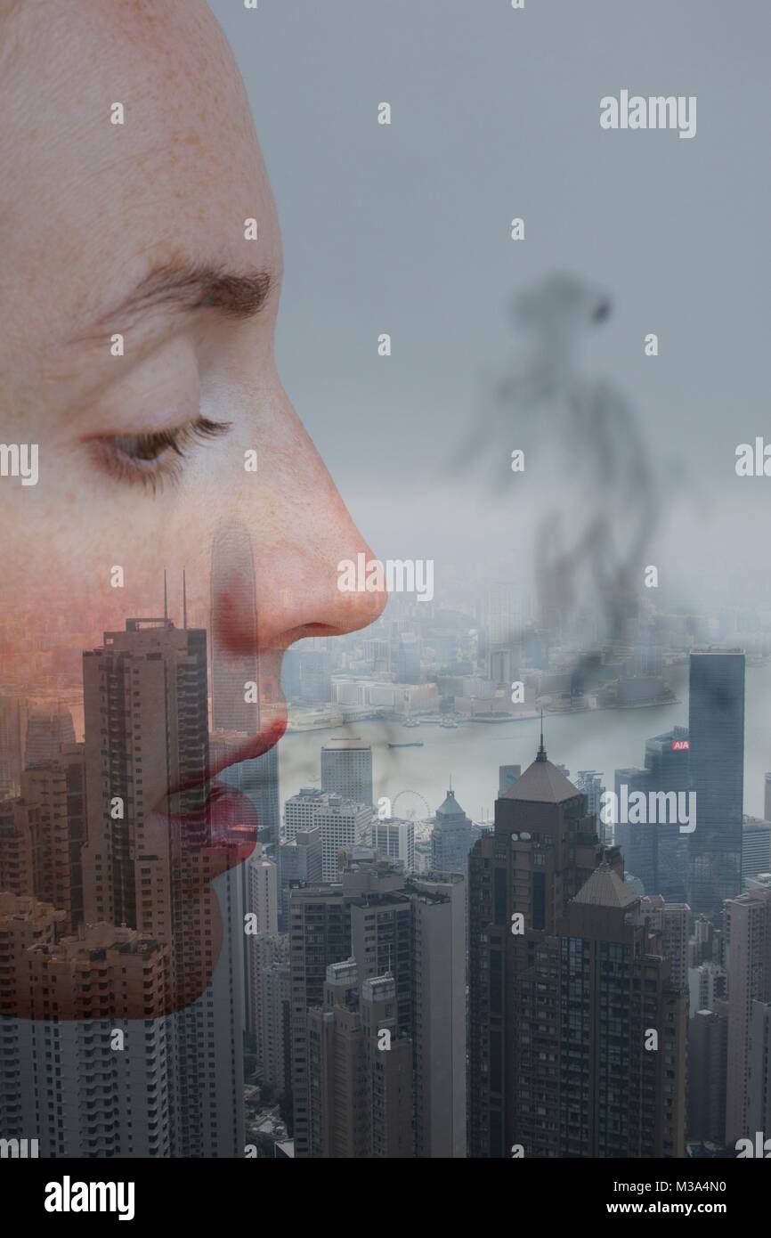 Modello rilasciato. Immagine concettuale, il profilo del volto femminile con fumo e città. Foto Stock