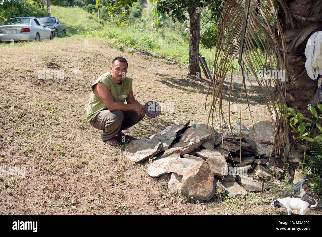 Un Maya Mopan artigiano scolpisce decorativo calendari Maya da ardesia locale in western Belize. Foto Stock
