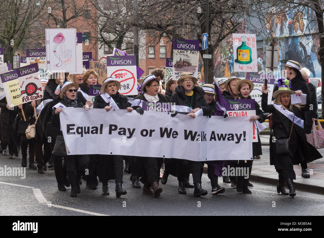Glasgow, Scotland, Regno Unito - 10 Febbraio 2018: le donne (e uomini) dimostrando in corrispondenza di una pari retribuzione protesta in Glasgow, guidato da donne abbigliate come credito suffragettes: Kay Roxby/Alamy Live News Foto Stock