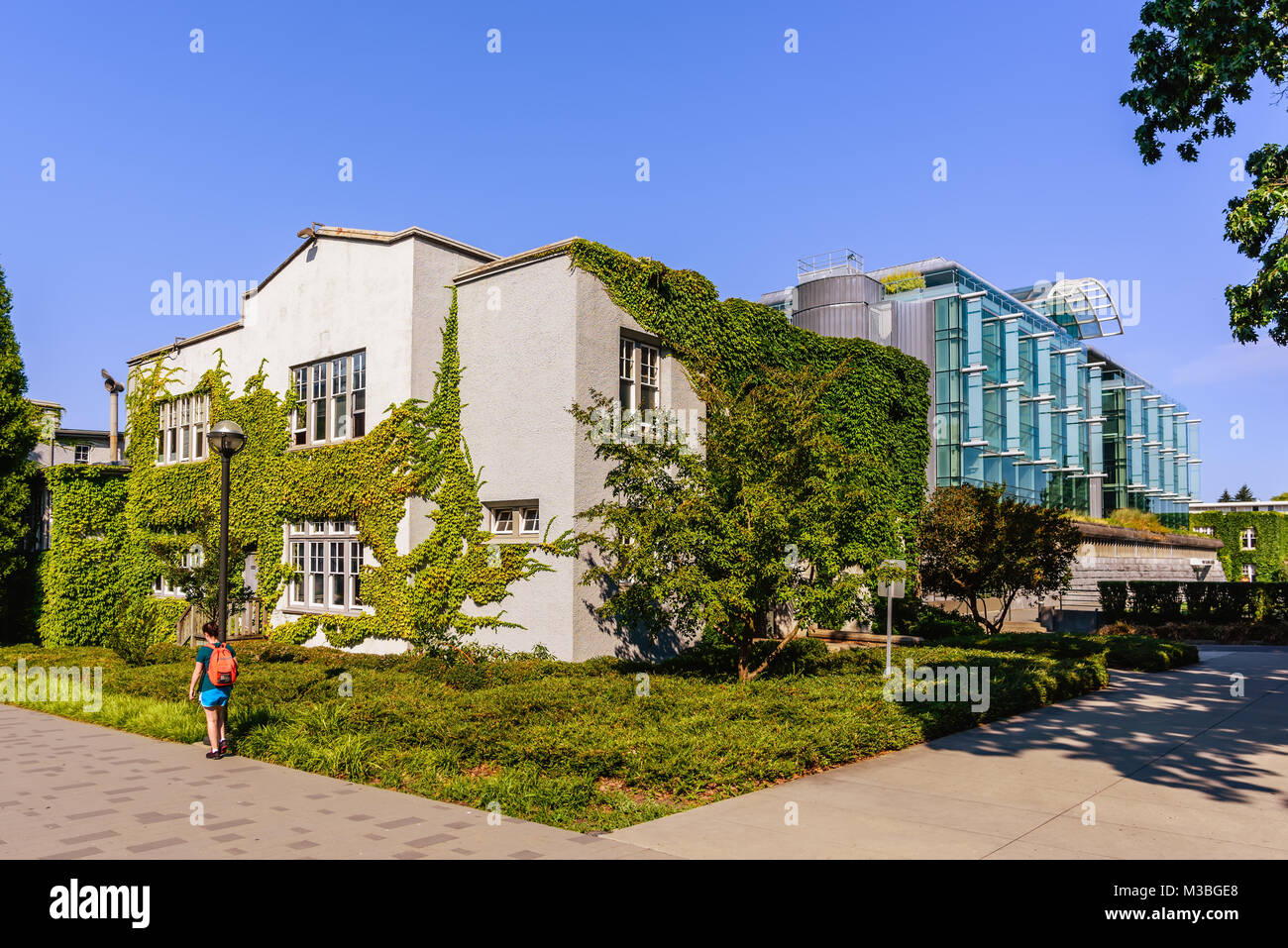 La facciata di un moderno edificio a più piani di vetro e cemento su una strada in una grande città Foto Stock