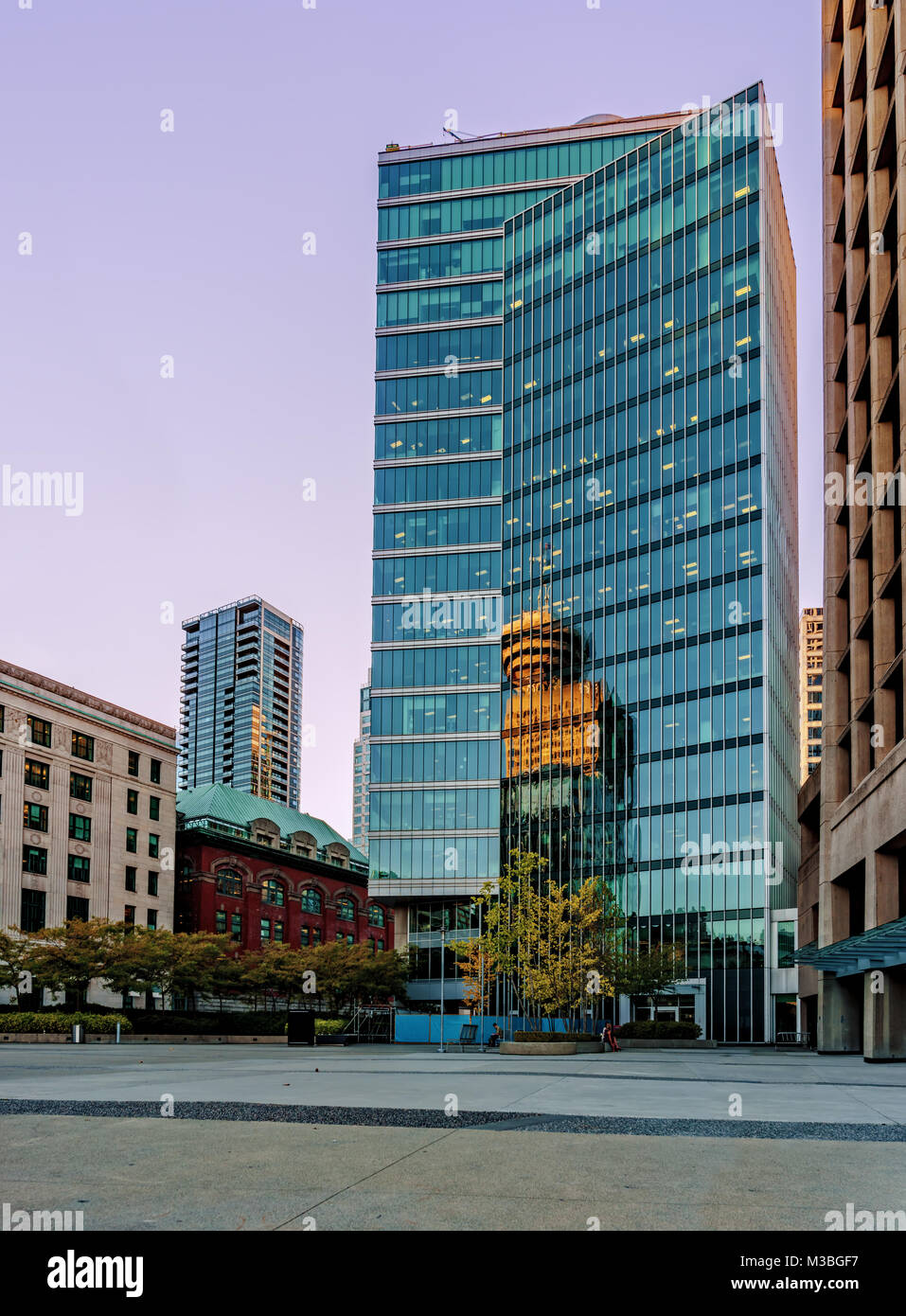 La facciata di un moderno edificio a più piani di vetro e cemento su una strada in una grande città Foto Stock