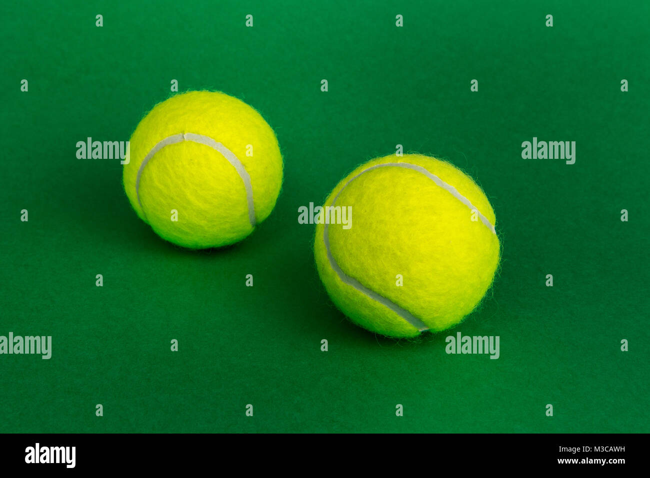 Due palle da tennis isolato su sfondo verde Foto Stock