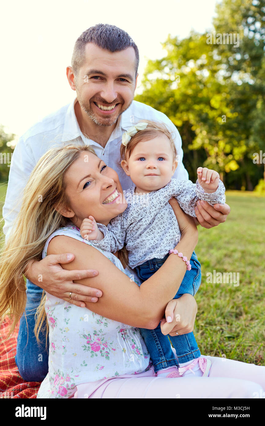 La famiglia felice in un parco in estate. Foto Stock