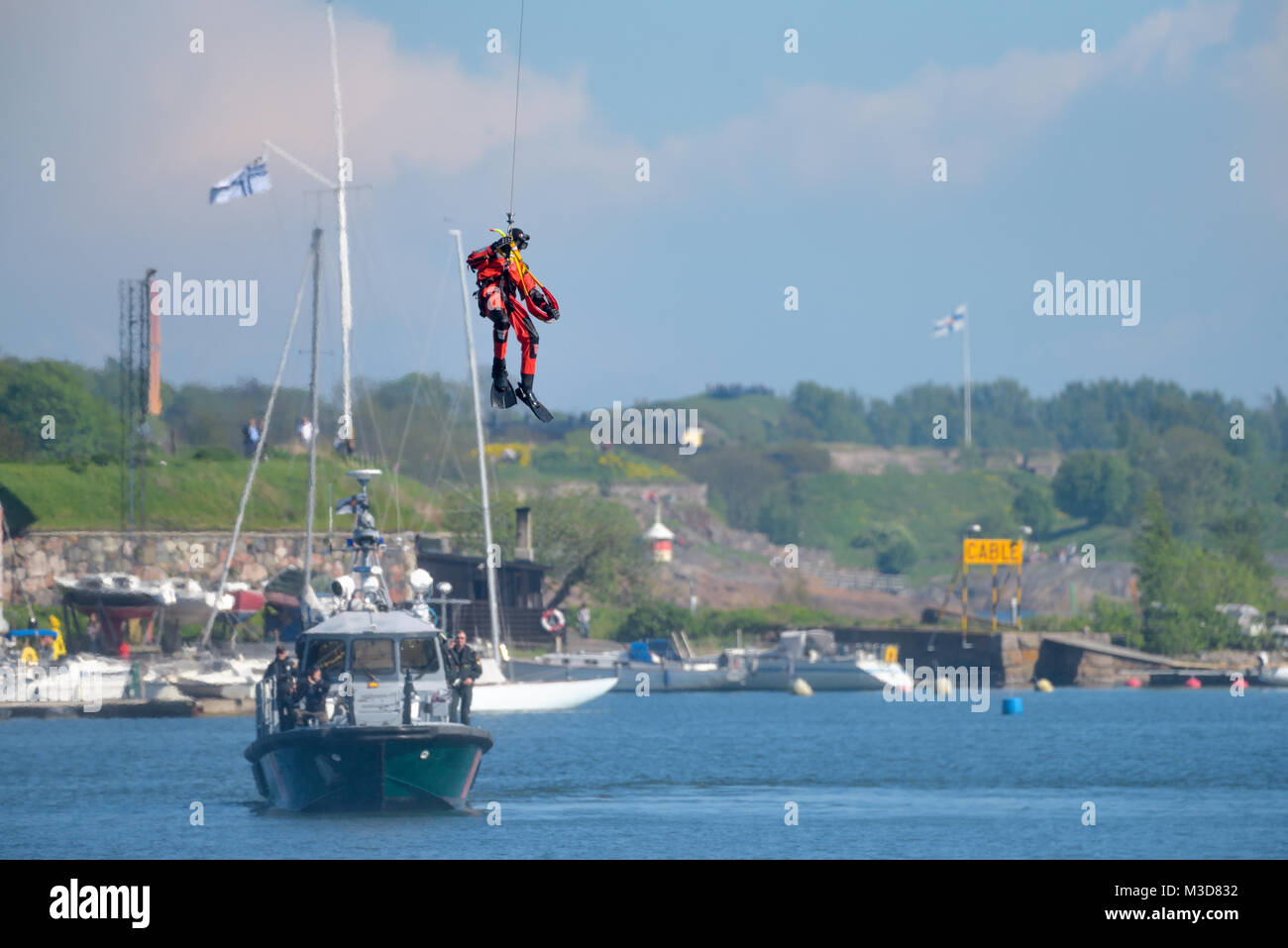 Helsinki, Finlandia - 9 Giugno 2017: finlandese non identificato Coast Guard rescue nuotatore scende giù per il Mar Baltico da un filo in esercitazione di soccorso o performa Foto Stock