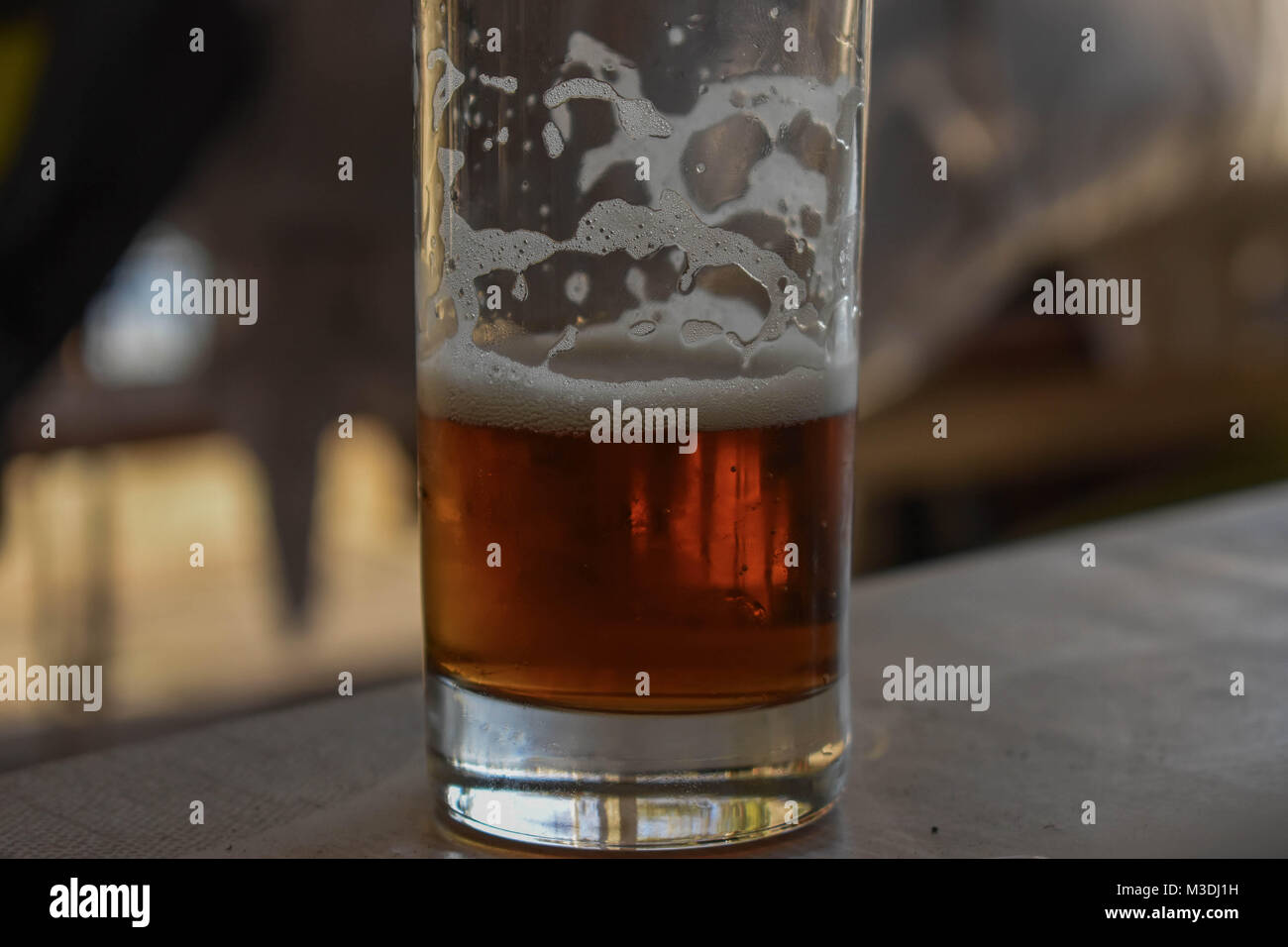 Bicchiere mezzo vuoto o mezzo pieno di birra Foto Stock