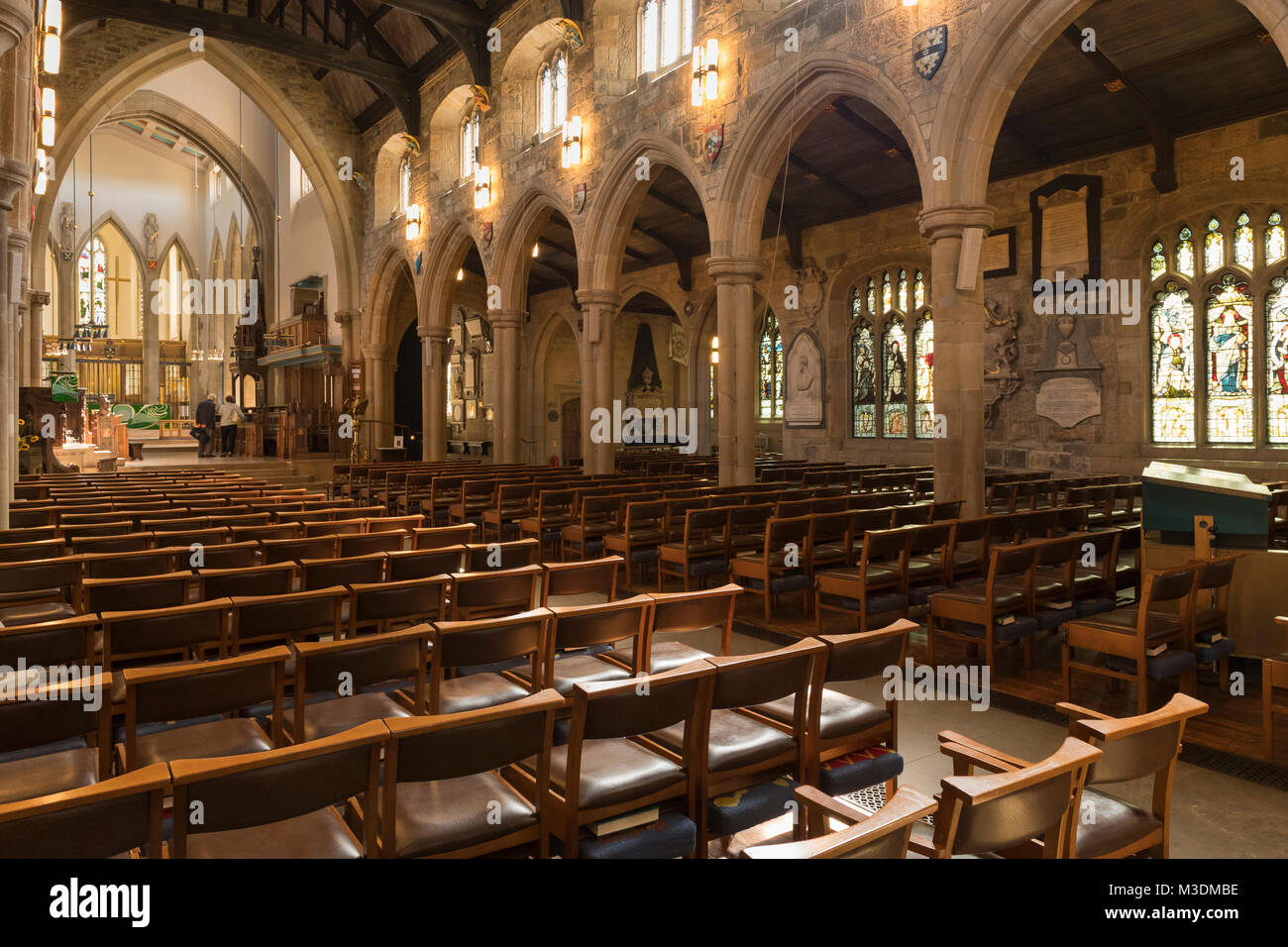 Interno della cattedrale di Bradford, vista rivolta verso est della navata con arcate in pietra, finestre di vetro colorato e file di sedili - West Yorkshire, Inghilterra, Regno Unito. Foto Stock