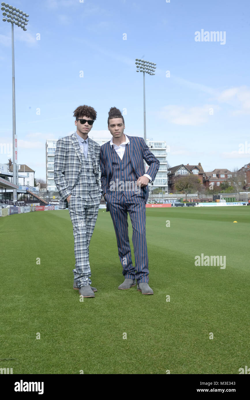 Due bello razza mista ragazzi indossando abiti su misura sono a cricket ground- splende il sole Foto Stock