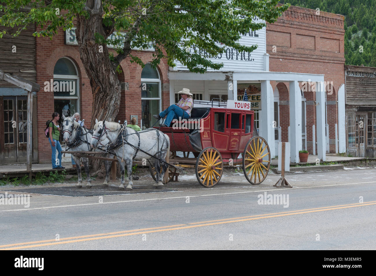 Virginia City, Nevada - Luglio 9, 2010: i turisti stanno parlando con la stagecoach driver per chiedere circa il noleggio di una carrozza per un giro intorno al vecchio argento Foto Stock