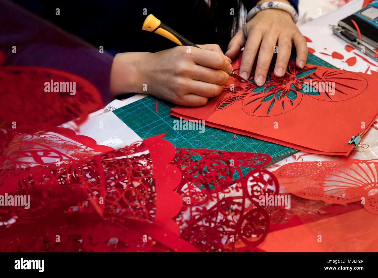 Un maestro cinese è impegnato in Jianzhi folk art - folk tradizionale cinese decorativo il taglio della carta Foto Stock