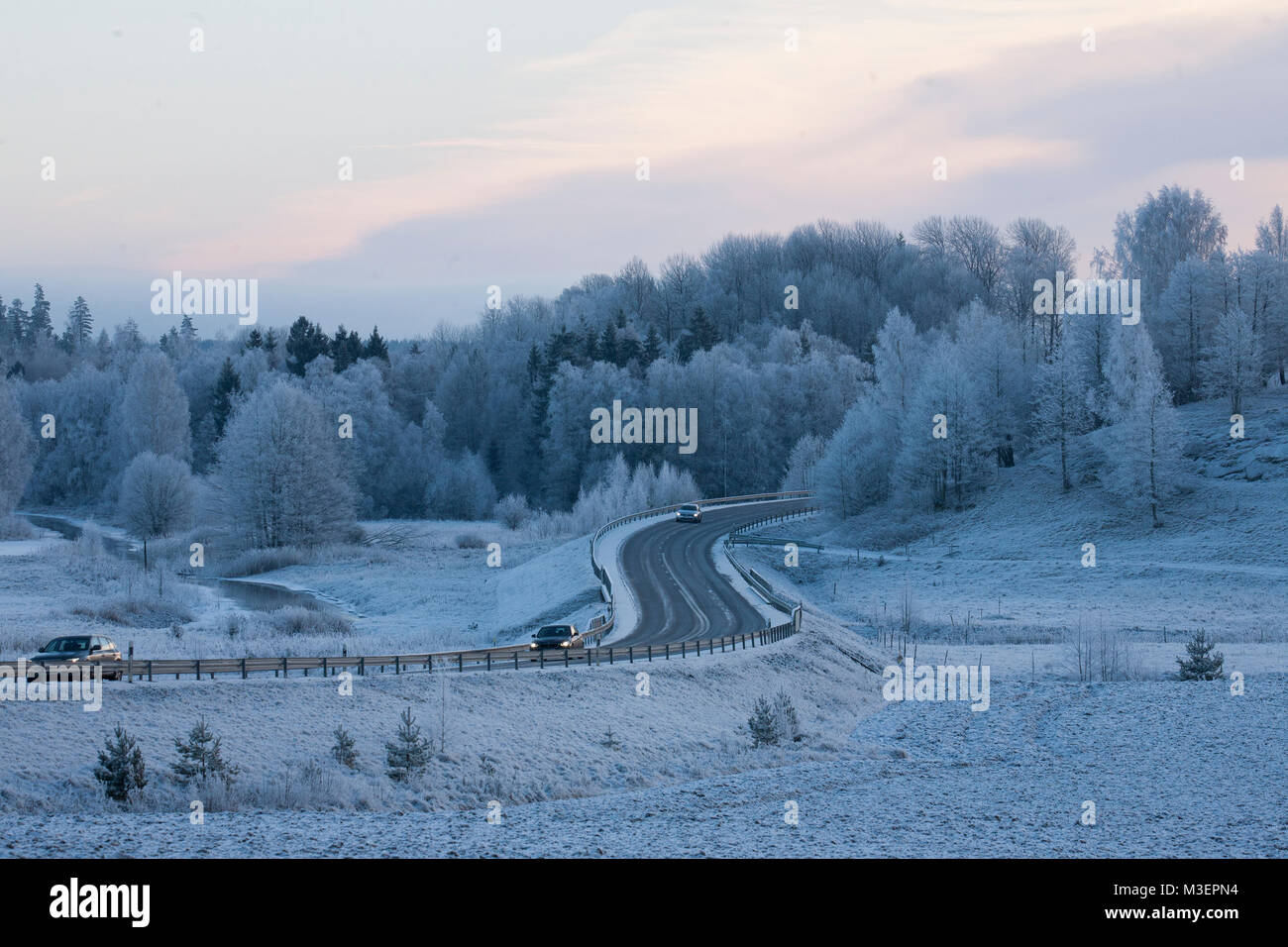 La strada si snoda attraverso il paesaggio invernale Foto Stock