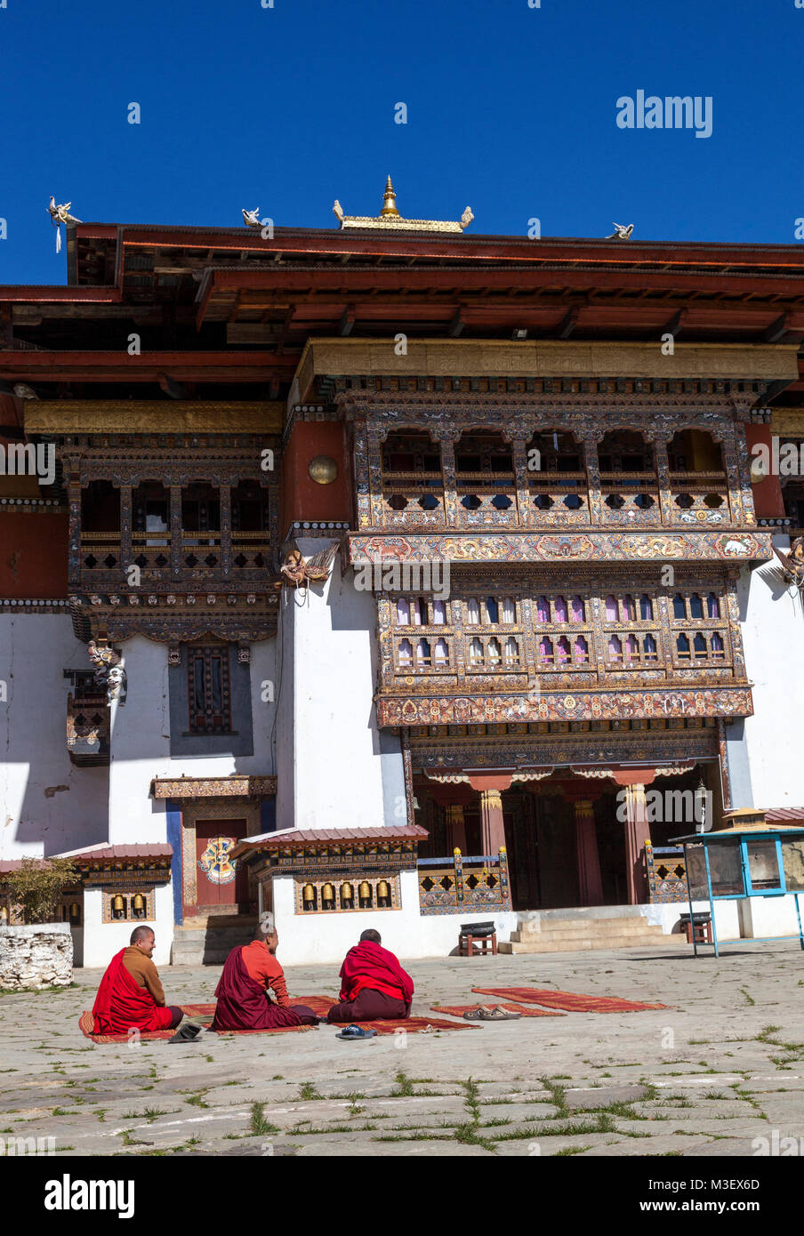 Phobjikha, Bhutan. I monaci buddisti seduto nel cortile del monastero Gangte Goemba (). Foto Stock