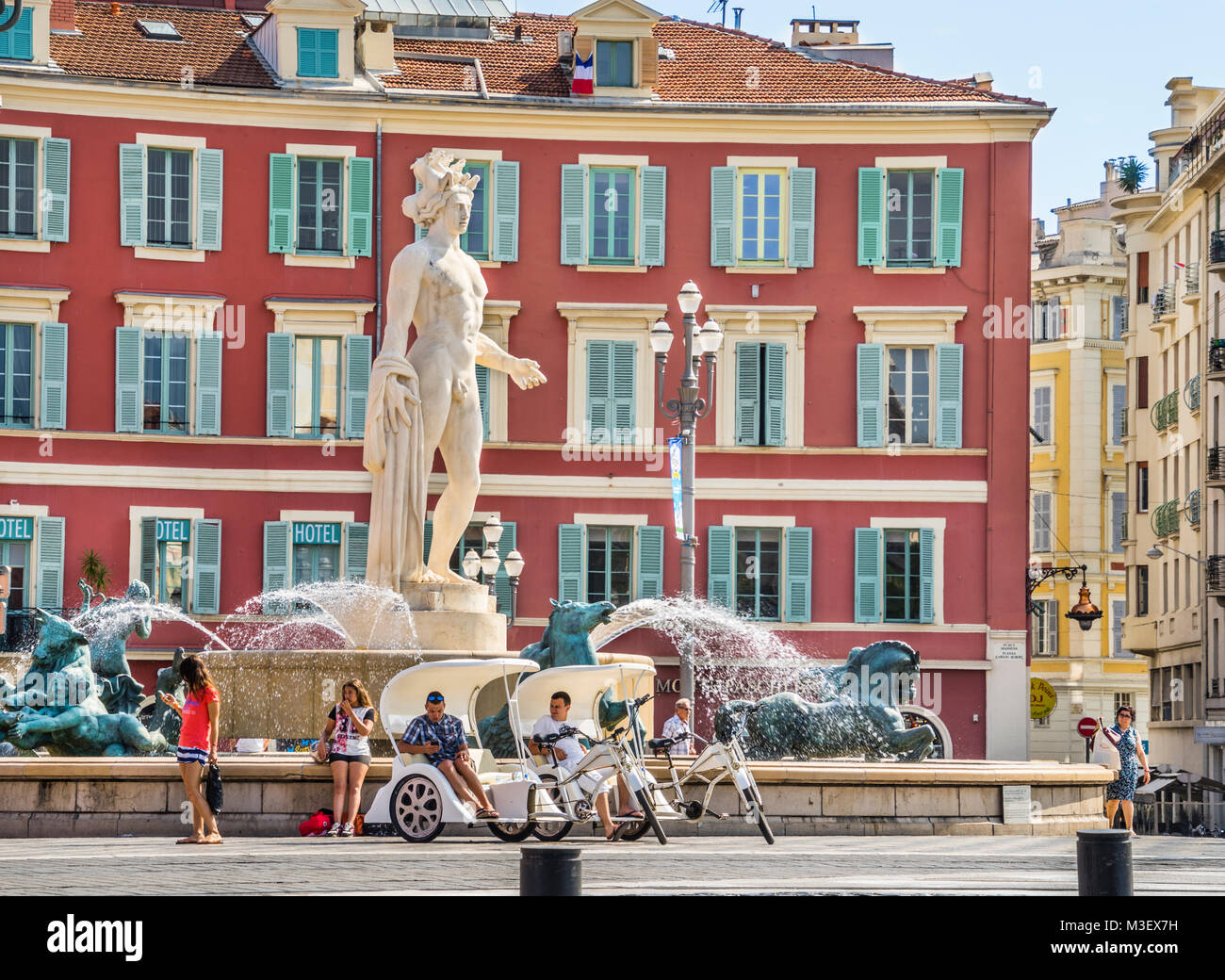 Francia, dipartimento Alpes-Maritime, Côte d'Azur, Nizza, Fontaine du Soleil con statua di Apollo su Place Masséna, sullo sfondo dei caratteristici Foto Stock