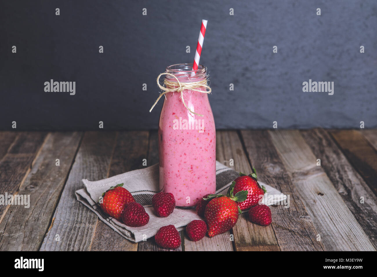 Bicchiere di deliziosi berry smoothie su sfondo di legno. Il piano portapaziente, vista frontale. Foto Stock