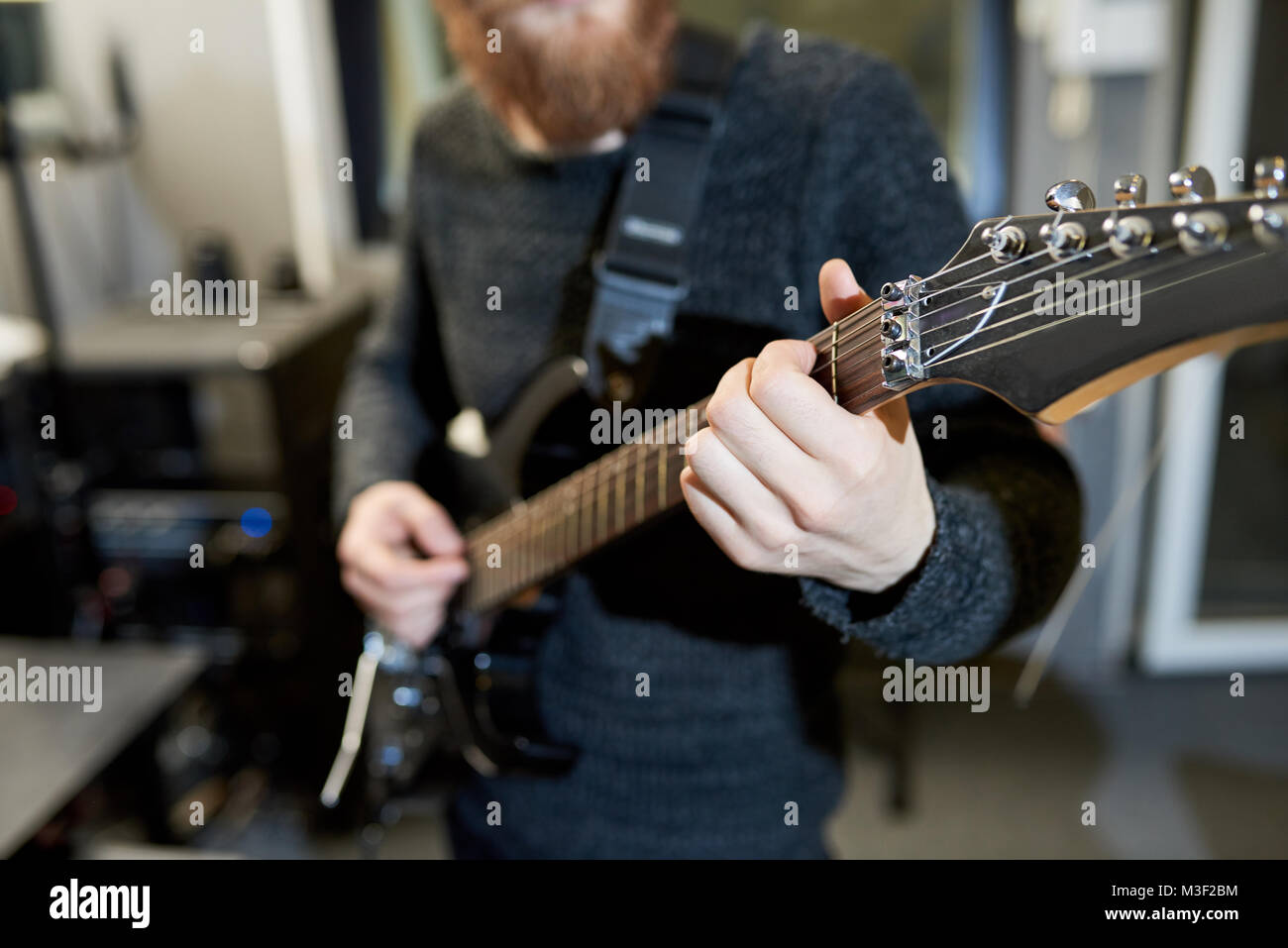Il tecnico del ramo la riproduzione di una chitarra elettrica in studio Foto Stock