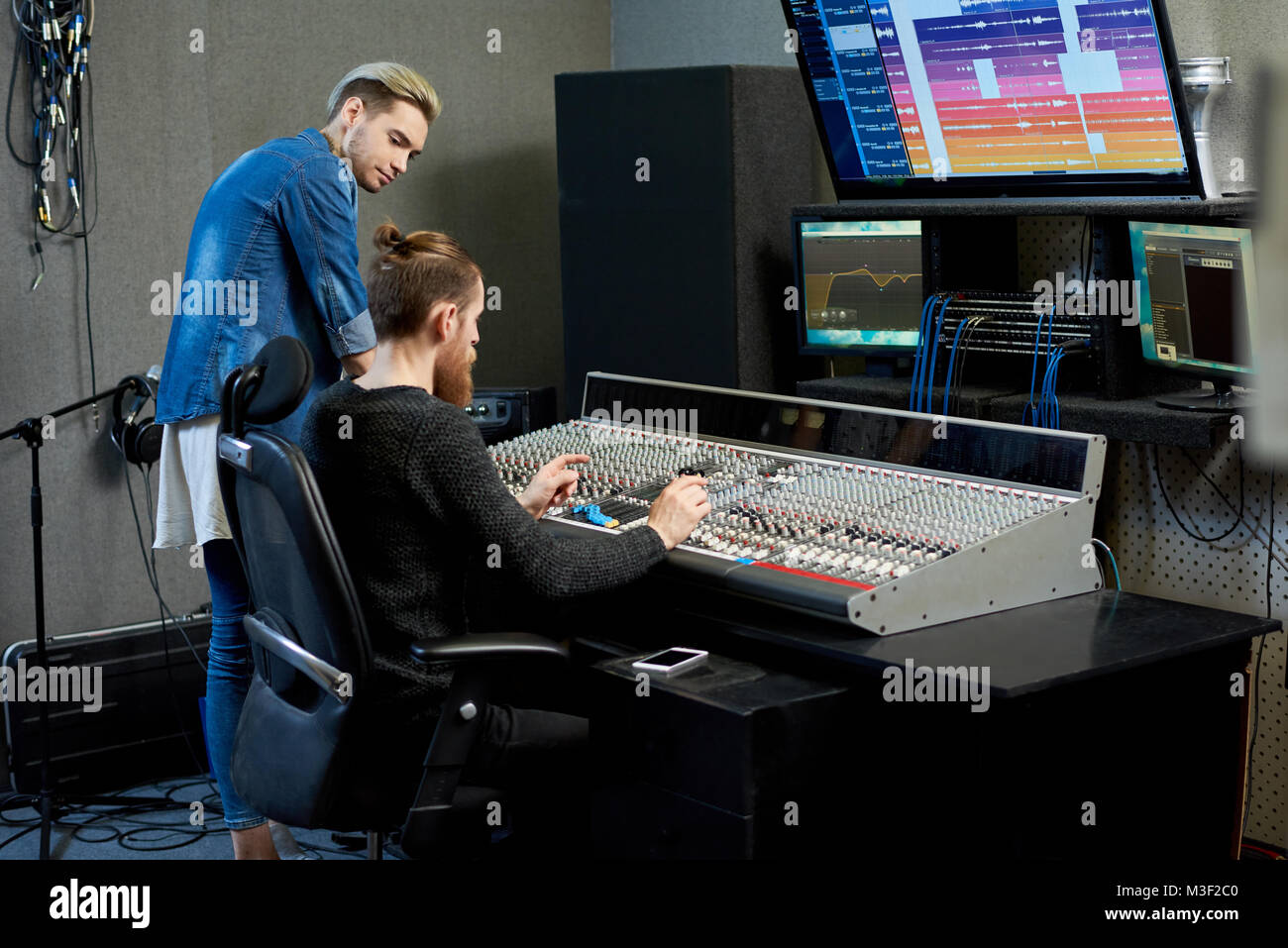 Ingegnere audio scegliendo i suoni per via insieme con il musicista Foto Stock