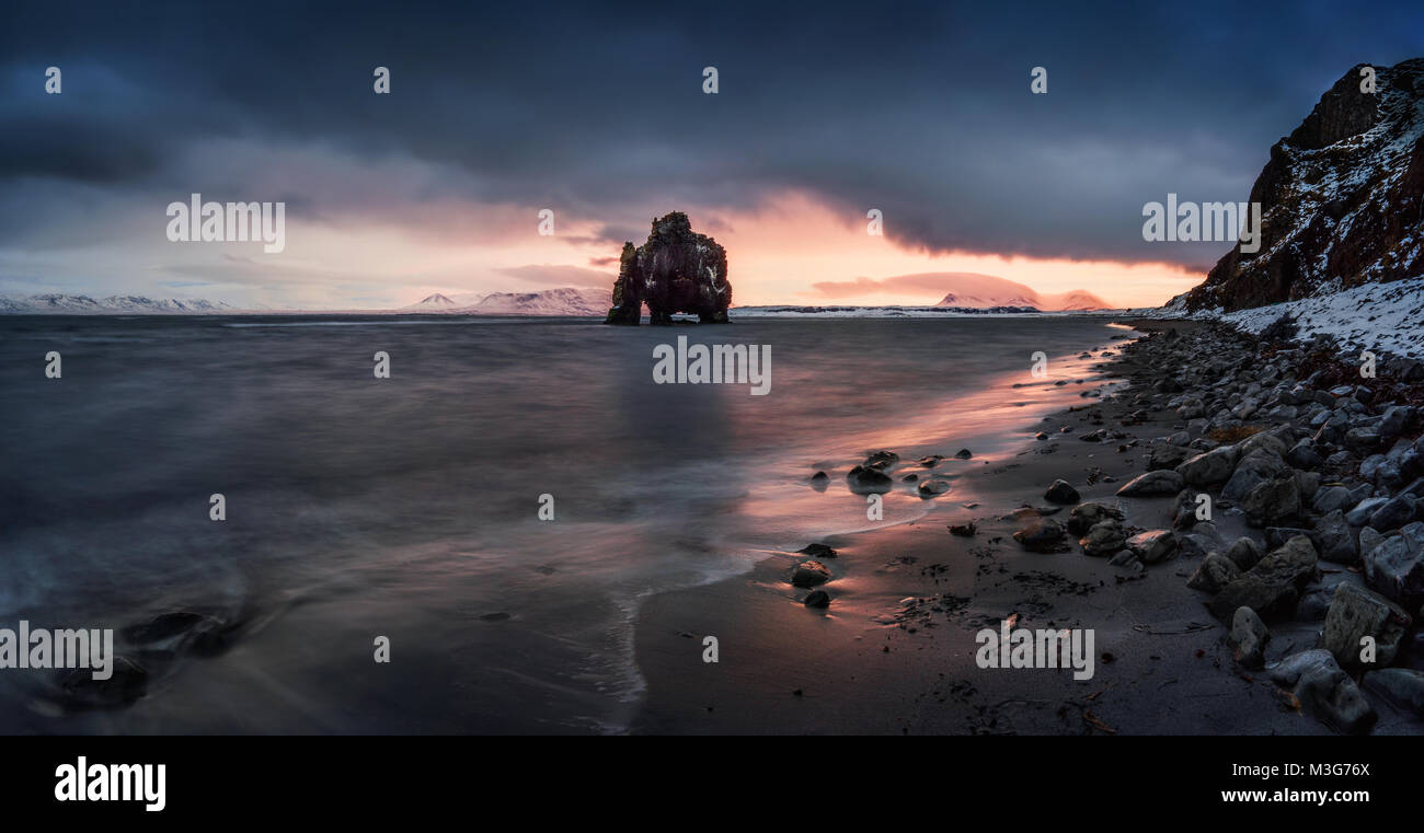 Nuvoloso Tramonto su Hvitserkur rock sulla spiaggia nera, Islanda Foto Stock