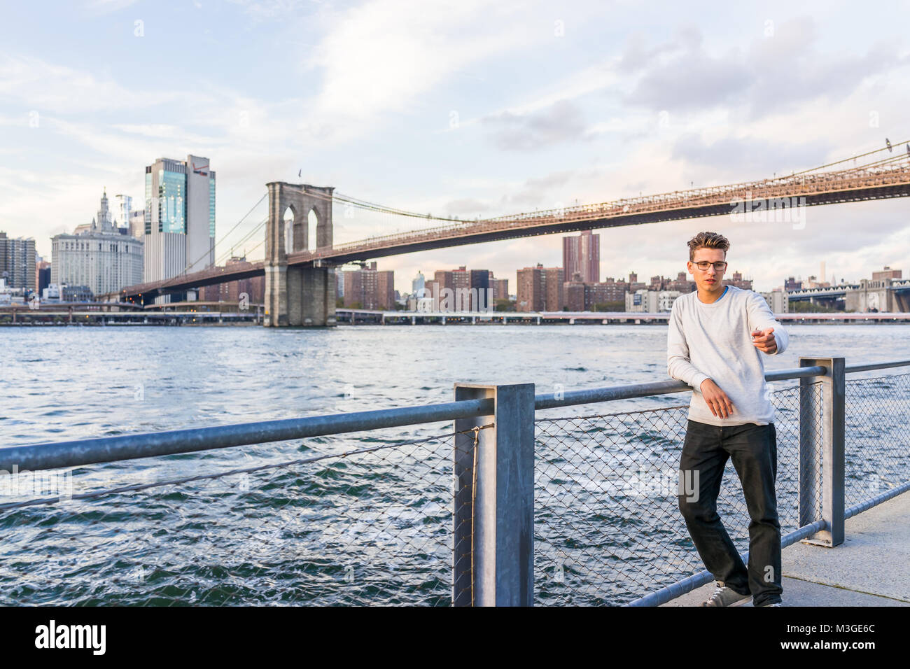 Brooklyn, Stati Uniti d'America - 28 Ottobre 2017: fuori all'aperto in NYC New York City Ponte di Brooklyn Park con coppia giovane uomo a scattare foto da East River, duri Foto Stock