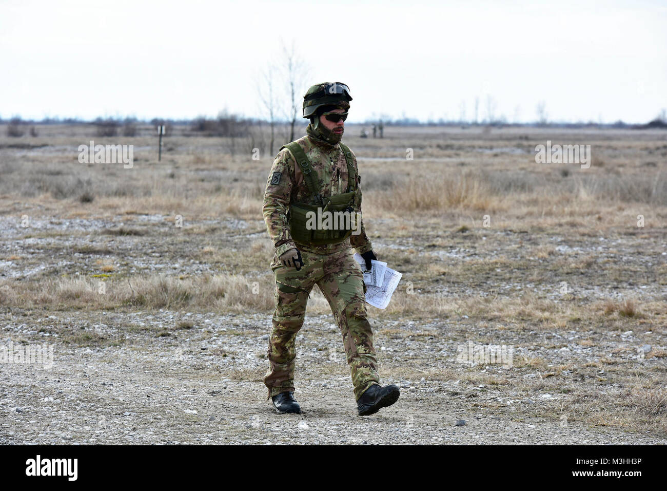 Un esercito italiano paracadutista dalla Brigata Julia Alpini Paracadutisti, naviga il terreno durante una navigazione terrestre per il giro di collaudo per il fante esperto Badge. I soldati devono completare un numero di prerequisiti e passare a una batteria di test classificato sulla base delle competenze di fanteria 6 febbraio 2018 a Cellina Meduna area, Pordenone, Italia. (U.S. Esercito Foto Stock