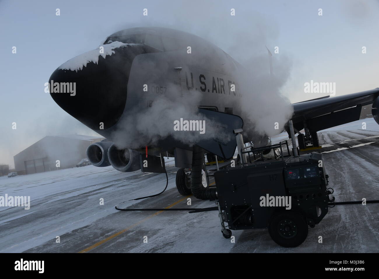 Un U.S. Air Force KC-135 dall'Iowa Air National Guard 185th dell aria ala di rifornimento è immersa in una nube di gas di scarico da un portatile di unità di riscaldamento essendo utilizzato per scaldare il cockpit in preparazione di un inizio di mattina di decollo in città di Sioux, Iowa il 10 febbraio 2018. Con la mattina presto temperature a due cifre al di sotto dello zero, equipaggio capi dal 185th ARW stanno preparando il velivolo per il volo durante il loro febbraio week-end di formazione. Stati Uniti Air National Guard foto di: Master Sgt. Vincent De Groot Foto Stock