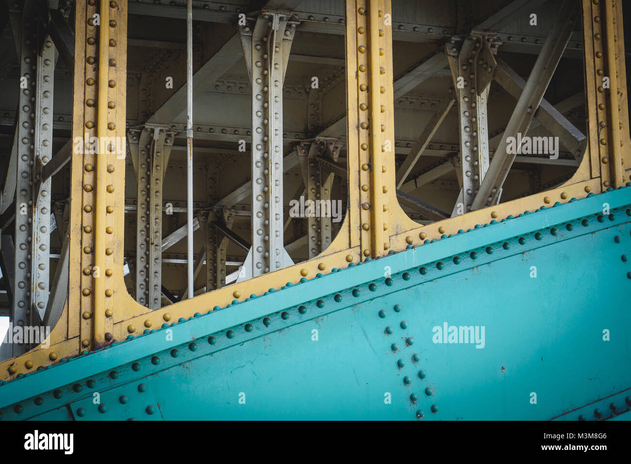 Travi di acciaio su un ponte ferroviario con le piastre di acciaio e i collegamenti rivettati. Formato orizzontale. Foto Stock