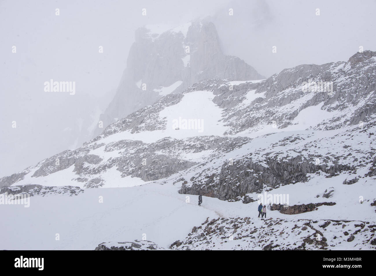 I turisti a piedi sotto le alte vette alpine di Fuente De; Picos de Europa; Spagna settentrionale. Accessibile una ambiente di montagna c/o una macchina di cavo. Foto Stock