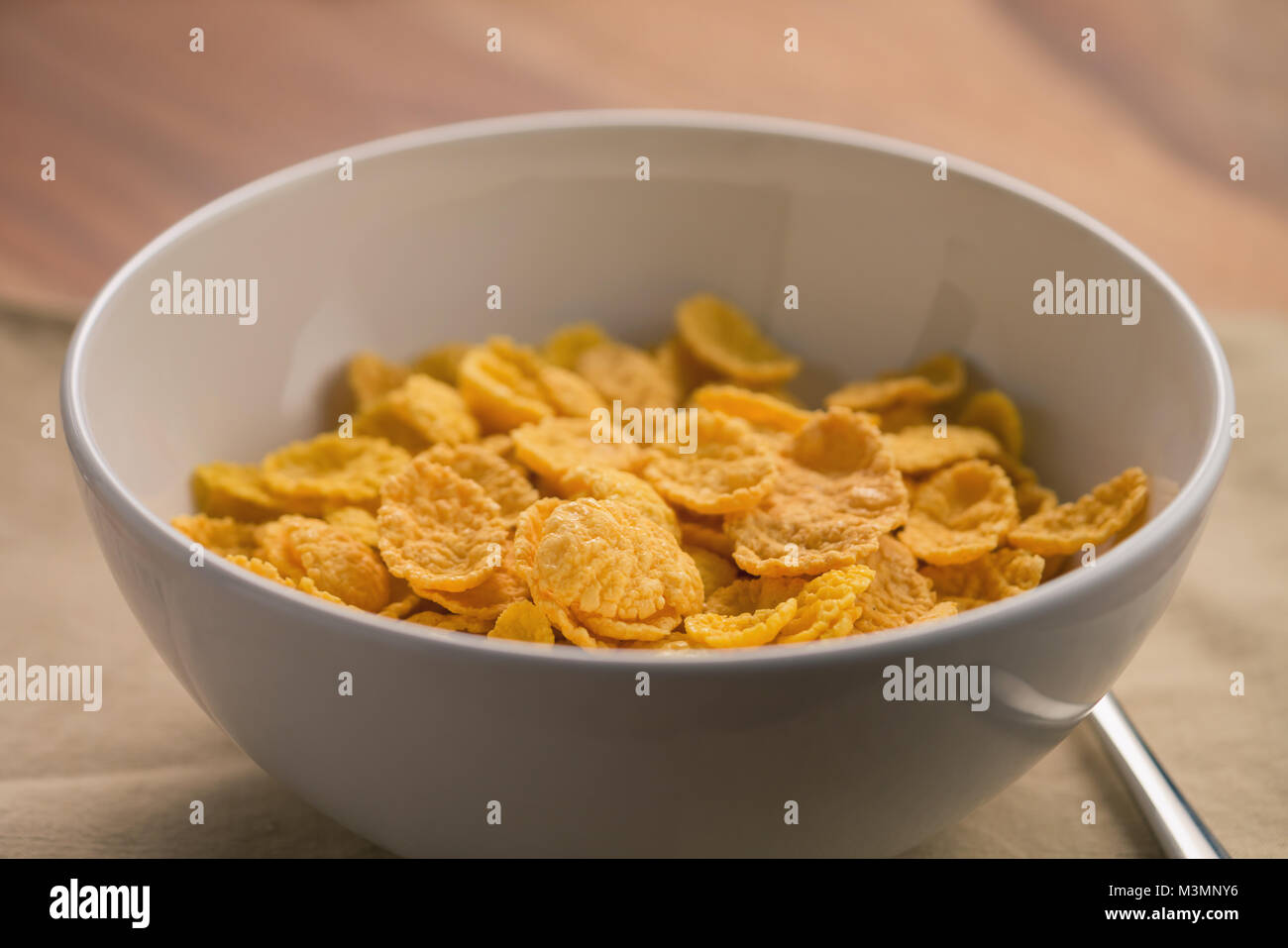 Fiocchi di mais in bianco ciotola per la prima colazione sul tavolo Foto Stock