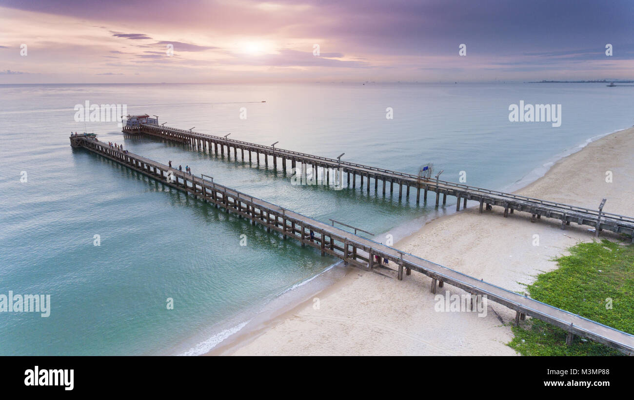 Forte e lungo il ponte di cemento al porto dalla terra al mare foto in outdoor sunrise bassa illuminazione. Foto Stock