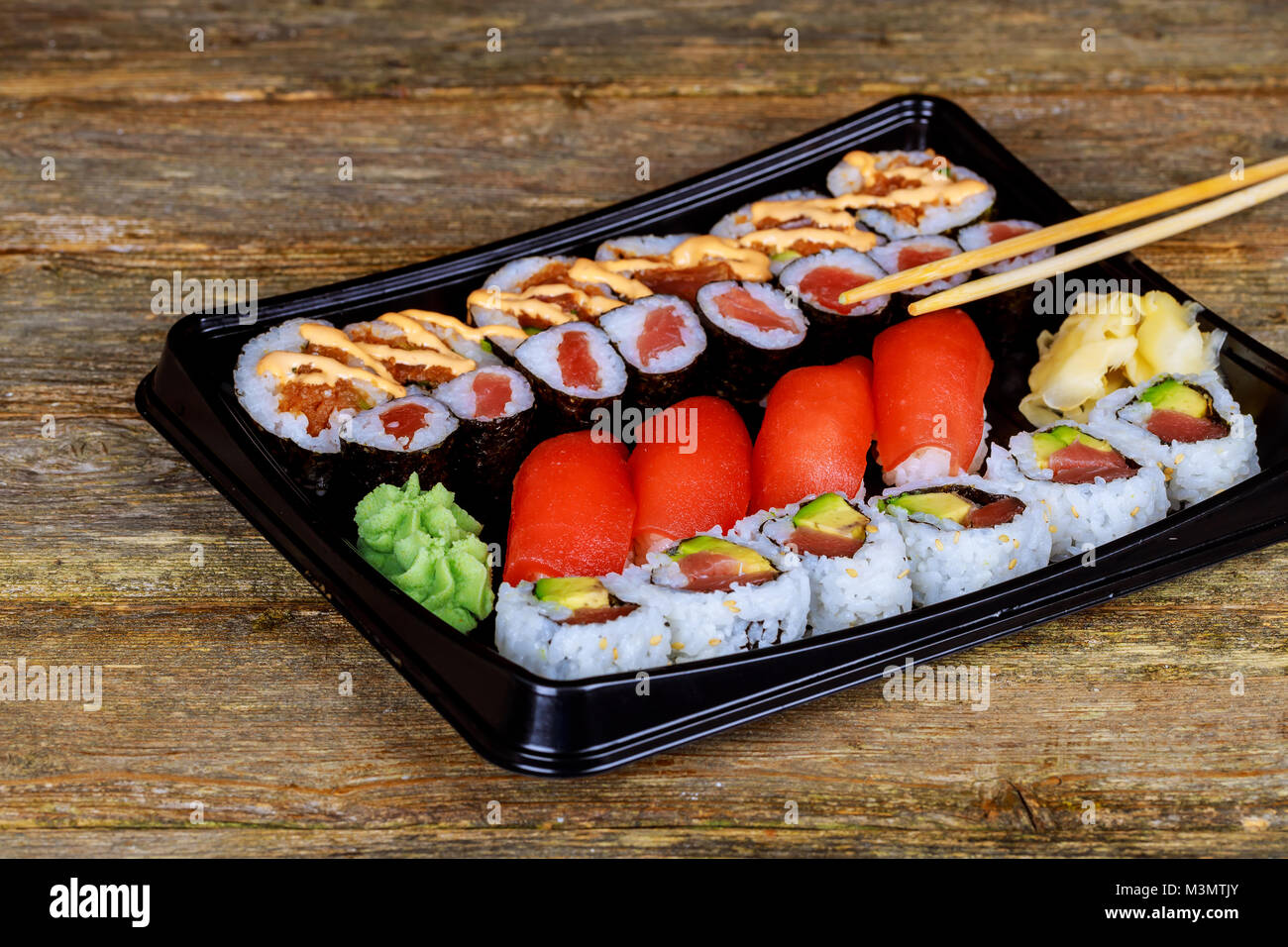 Impostare assortiti di sushi servita in una scatola di plastica sul tavolo di legno Foto Stock