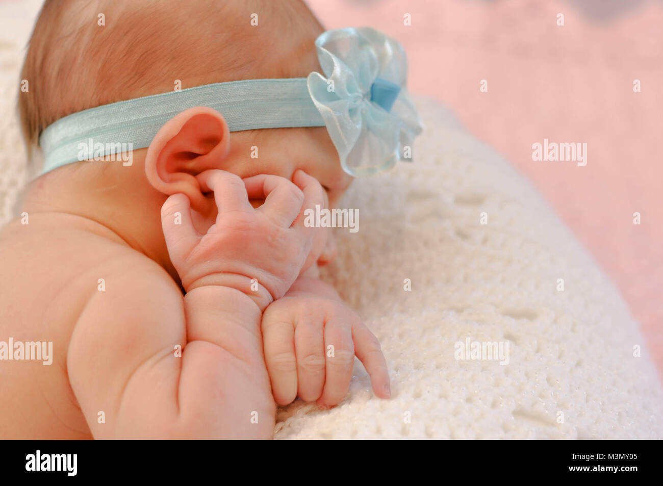 Neonato toccando il suo orecchio Foto Stock