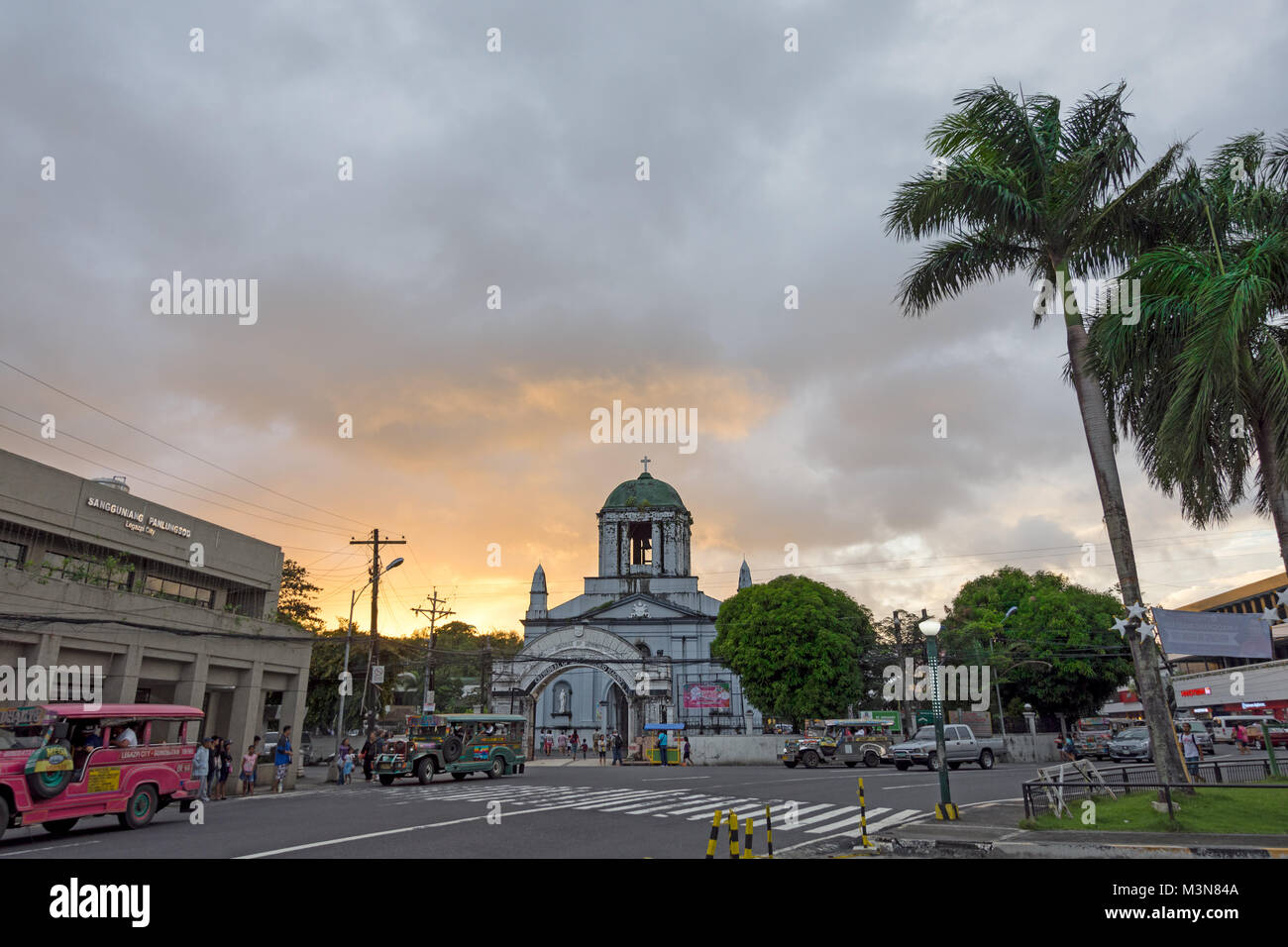 Cattedrale di San Gregorio Magno (St. Gregorio Magno) nella città di Legpazi, Albay, Filippine impostato su un tramonto e palme. Foto Stock