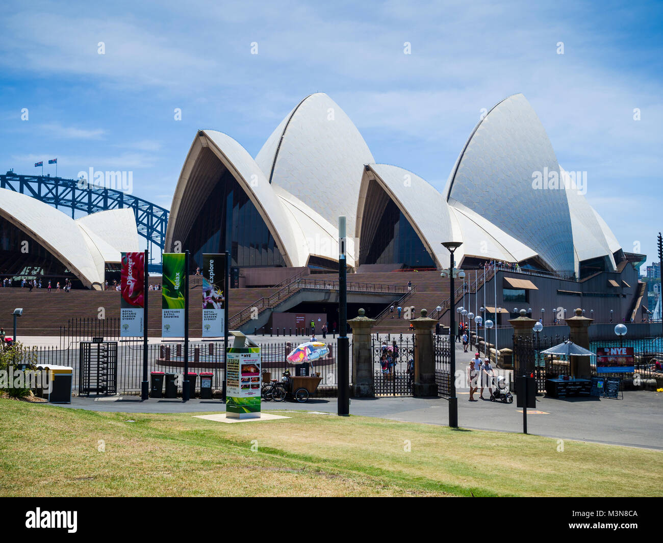 Vista della Sydney Opera House dall'interno del Royal Botanic Garden con scorcio di Harbour Bridge in distanza, Sydney, NSW, Australia Foto Stock