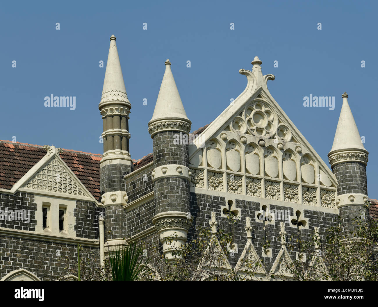 Architettura: Close up di un edificio con finestre ad arco ,tegole del tetto e la muratura di pietra vicino a Mumbai, India Foto Stock