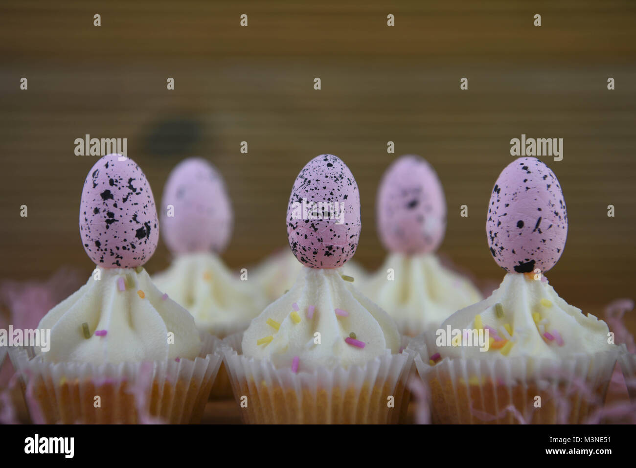 Una deliziosa casa cotto tempo di Pasqua tortini di cioccolato decorate con rosa uova di Pasqua Foto Stock