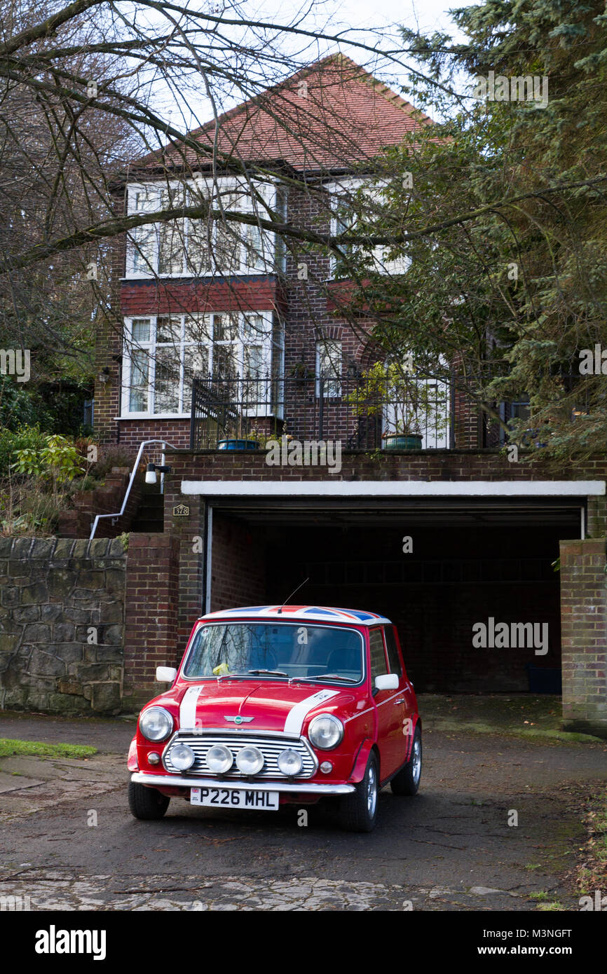Un classico, Red Mini Cooper auto con Unione Jack tetto e grandi luci per nebbia nella parte anteriore di uno stile di vita di lusso casa. Foto Stock