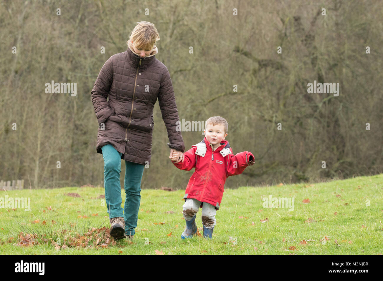 La madre e il bambino a piedi all'aperto su un giorno inverni. Herefordshire, Regno Unito. Foto Stock