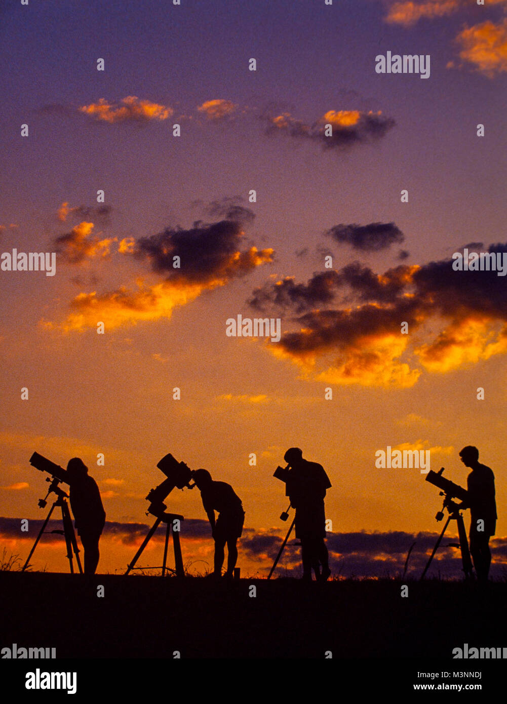 Gli astronomi dilettanti con i loro telescopi attendere il crepuscolo del cielo per scurire. Foto Stock