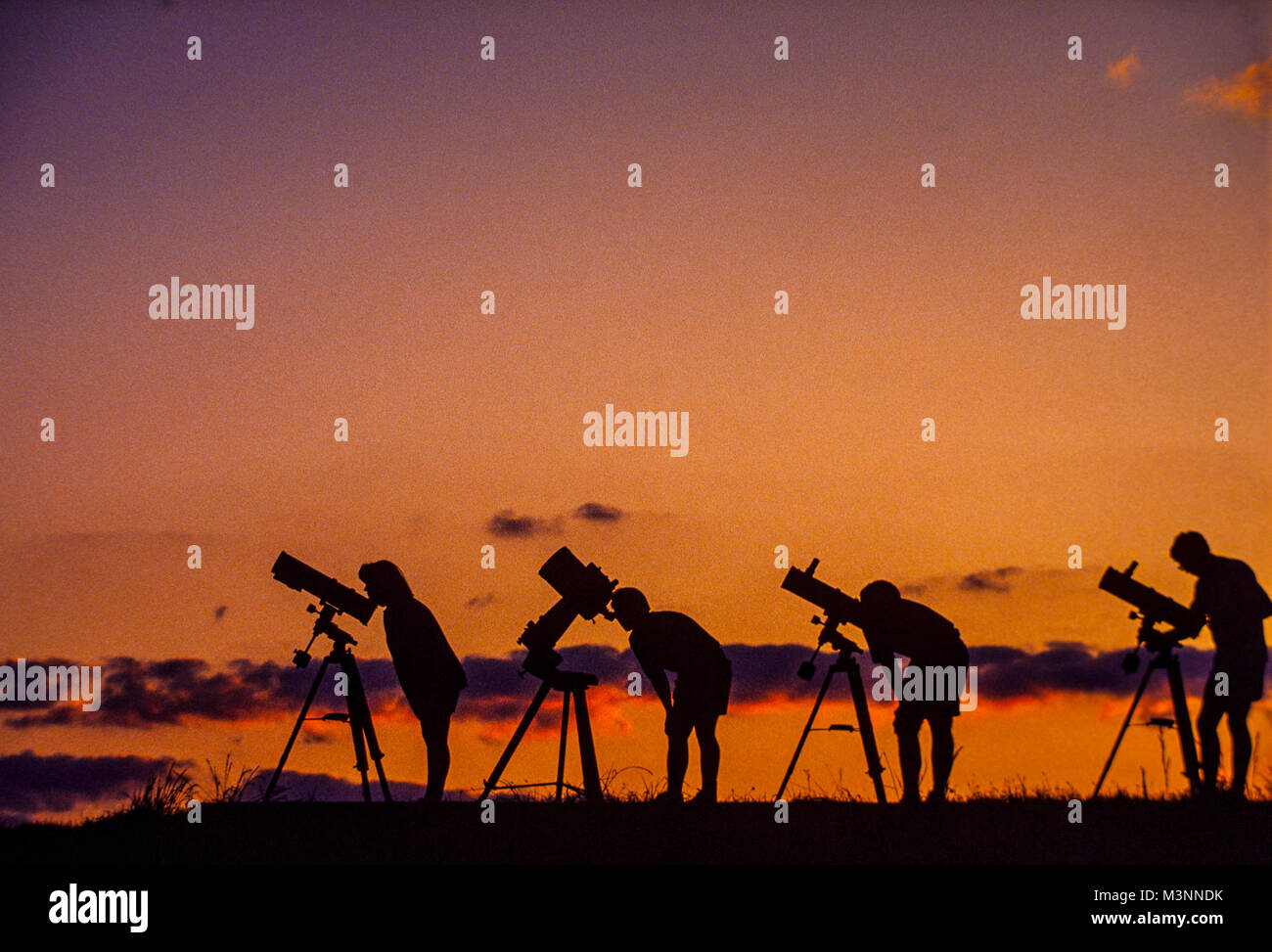Gli astronomi dilettanti con i loro telescopi attendere il crepuscolo del cielo per scurire. Foto Stock