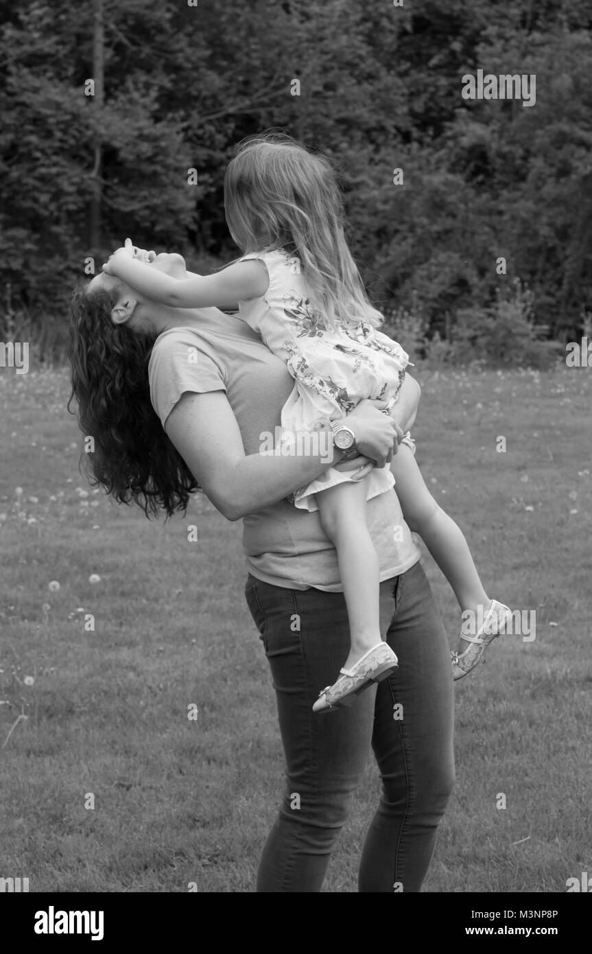 Madre e figlia insieme giocando in un parco Foto Stock