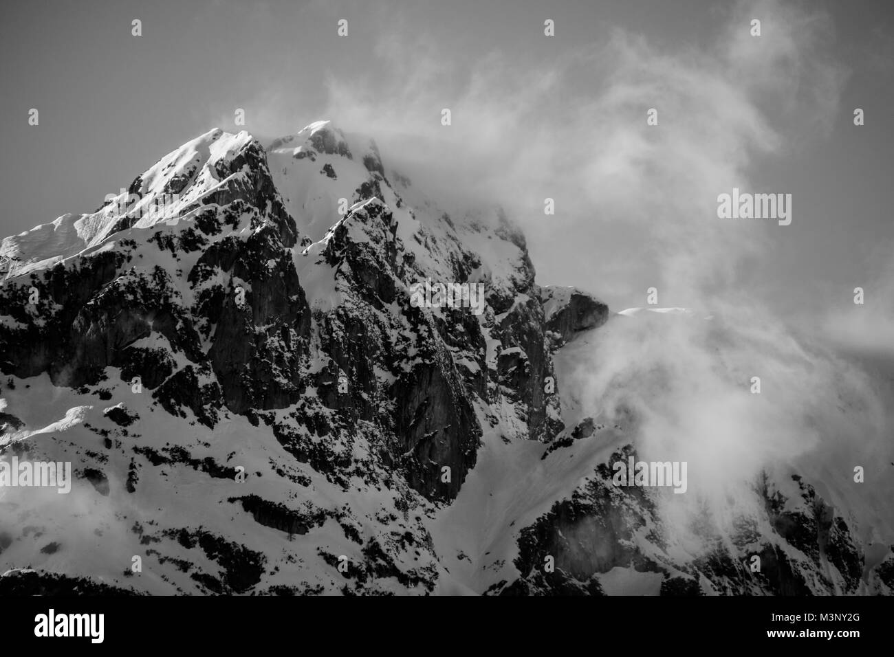 Blizzard disturbare la neve sulla sommità di un robusto picco alpino sulle montagne in Austria Foto Stock